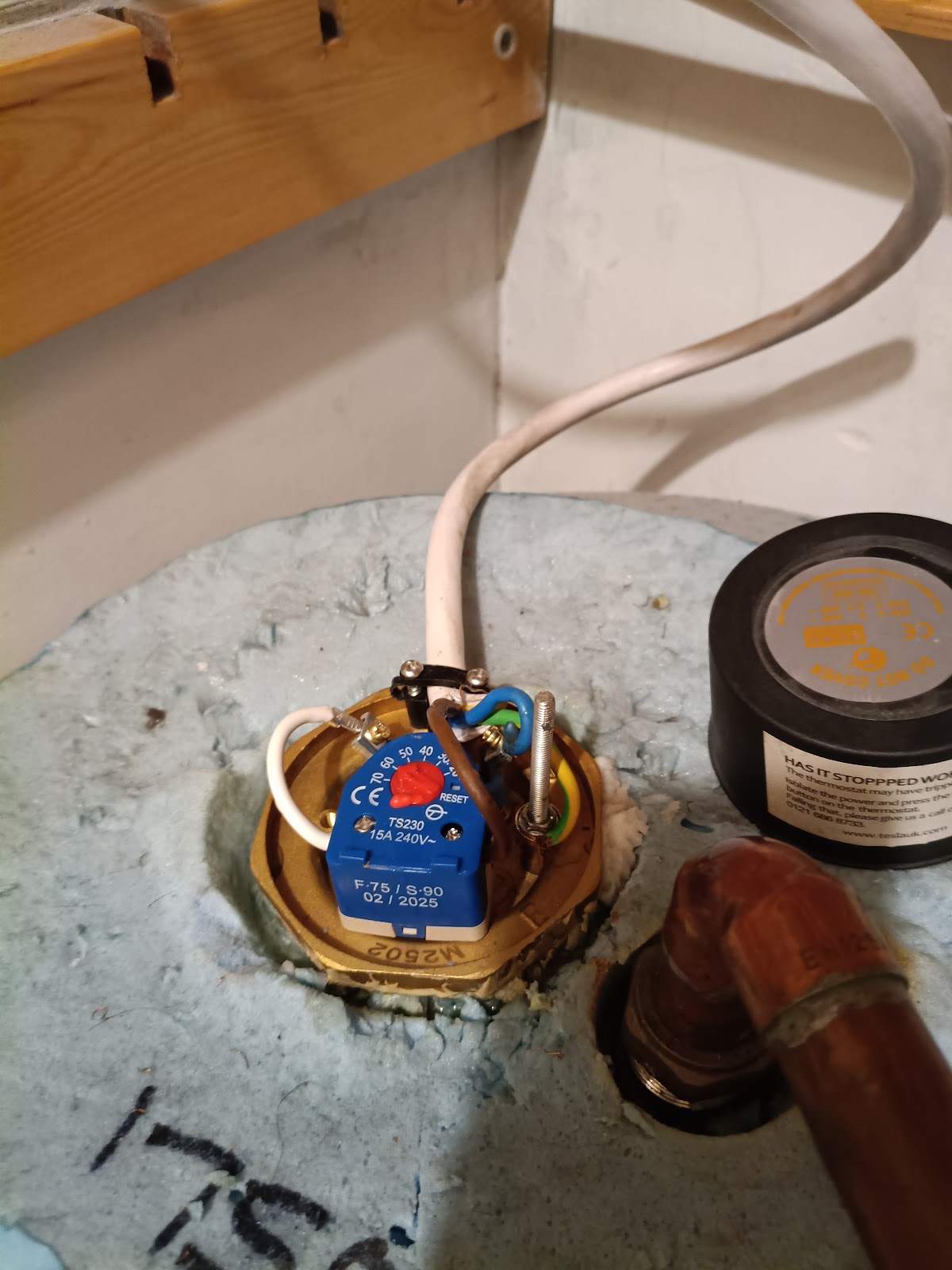 Immersion heater thermostat being wired up on a hot water cylinder